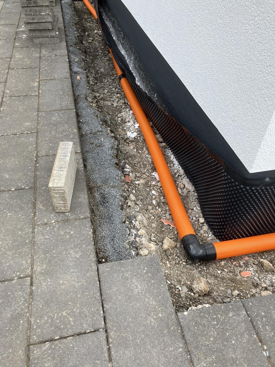 Drainagerohr an der Gebäudewand vor dem Verfüllen