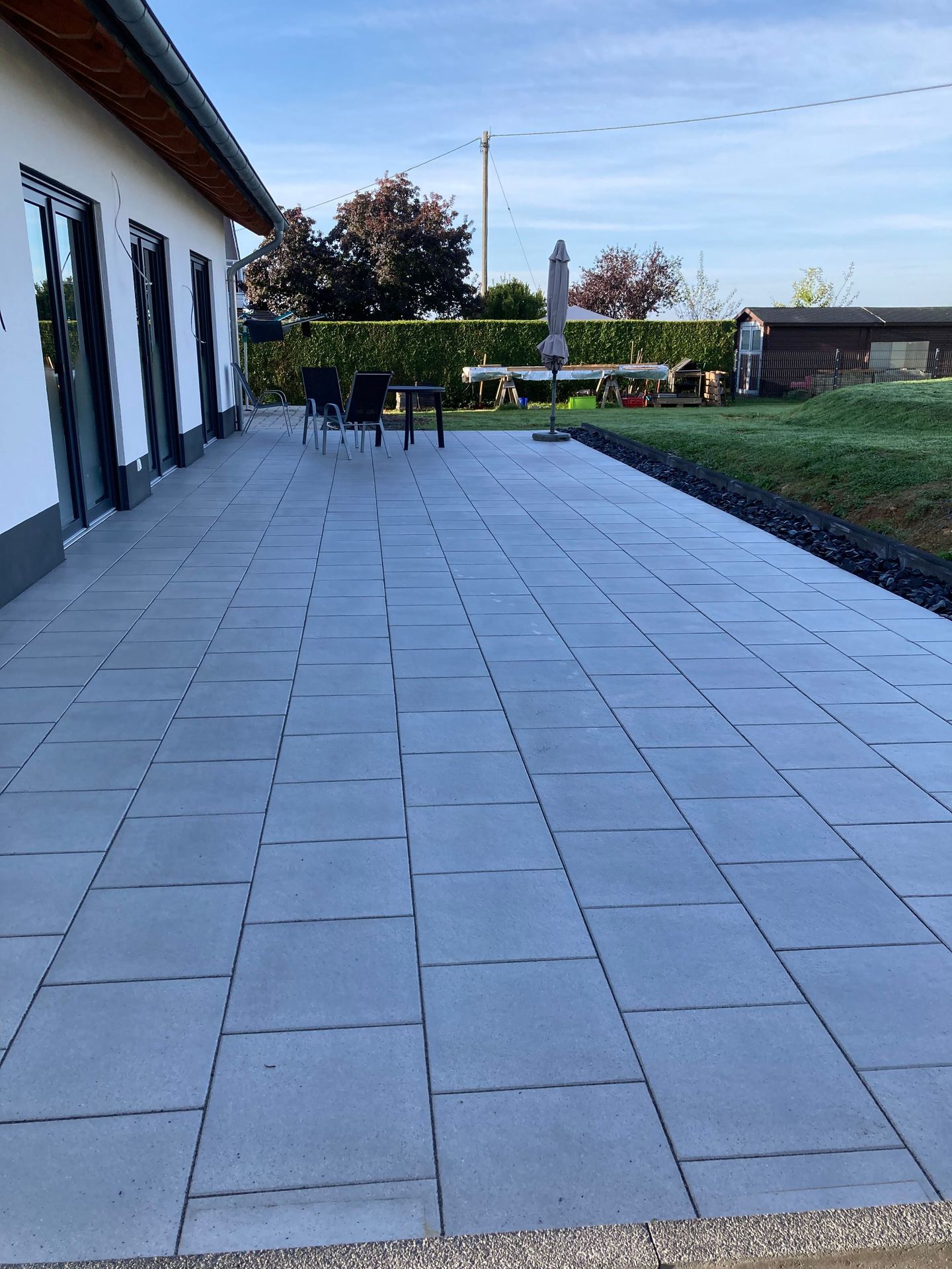 Frisch verlegte Pflaster-Einfahrt in Herringbone-Verlegemuster vor einem modernen Wohnhaus